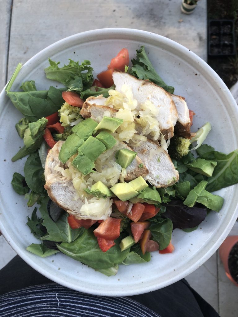 dark leafy greens with grilled chicken and avocado on top