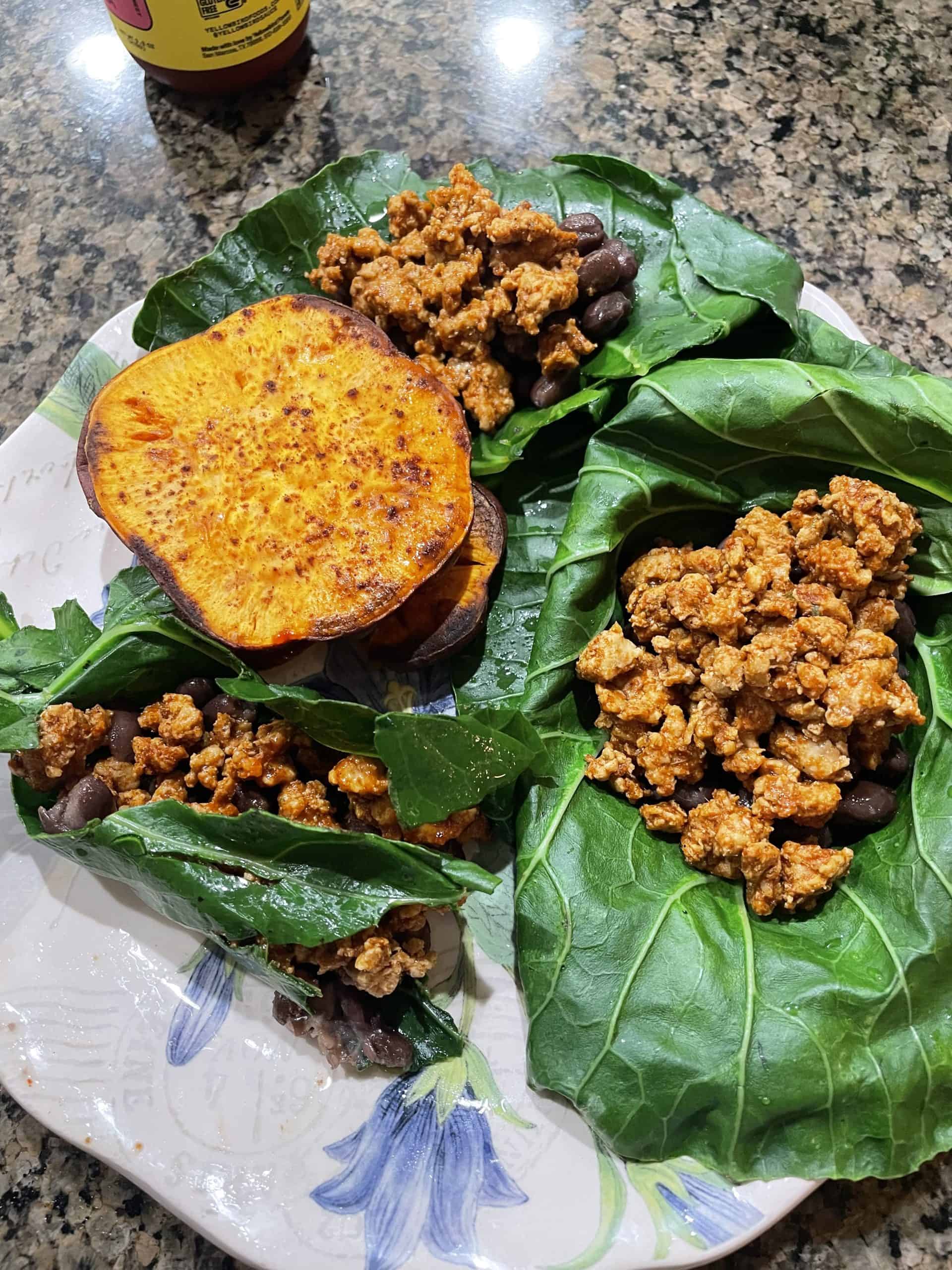 turkey means on top of collard greens with roasted sweet potatoes on the side