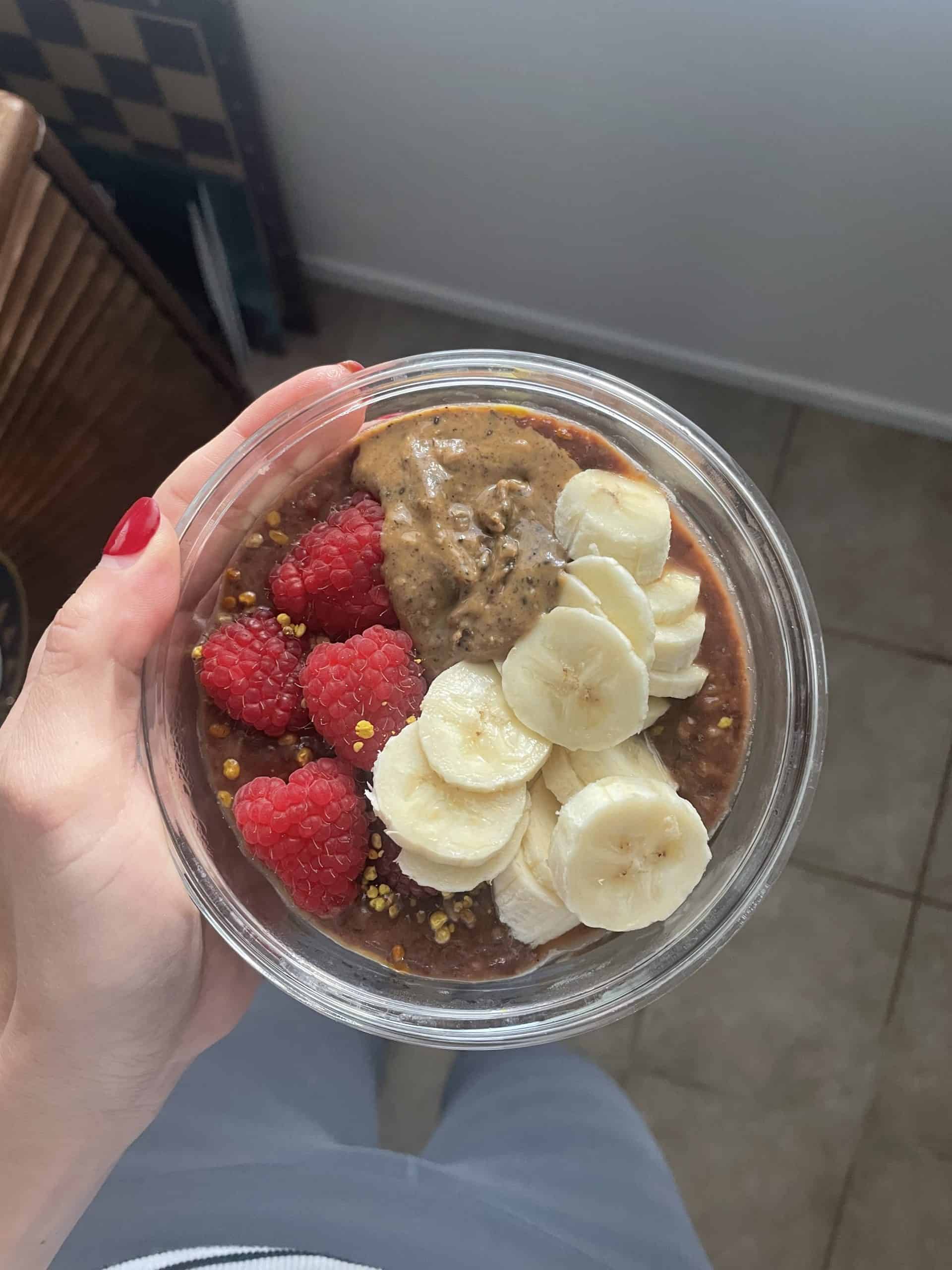 bowl of protein oatmeal with banana, raspberries and nut butter